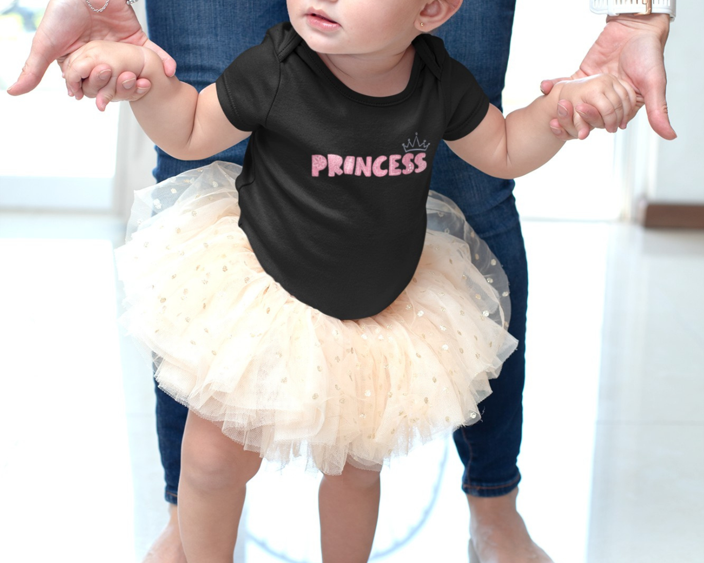 On the front of this custom baby girl onesie is the word princess in a light pink color with a crown over the last two letters of the word.