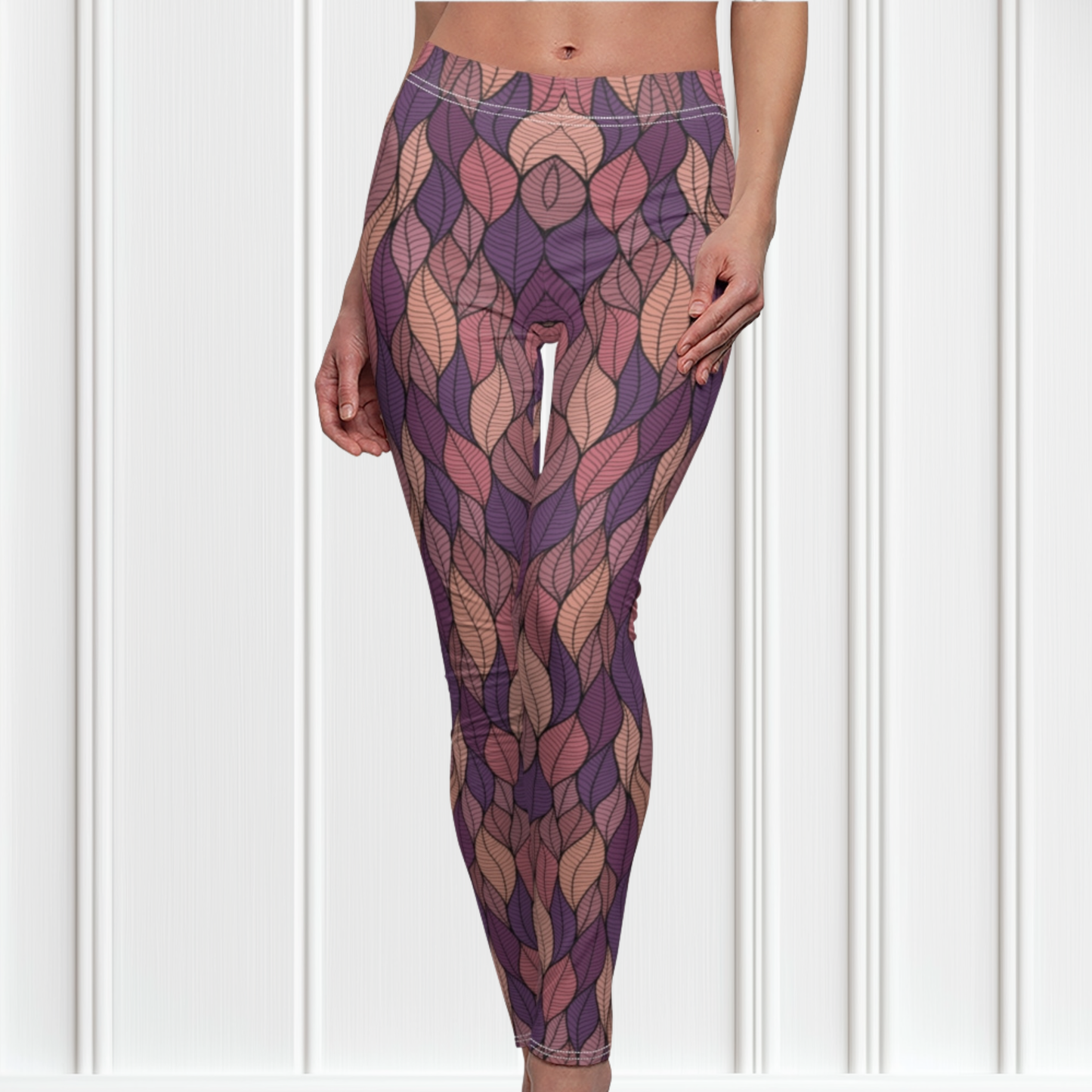 These custom colorful handmade women's leggings have a pattern of multicolored leaves from top to bottom, the leaves are light pink, purple, mauve and beige giving the leggings a vibrant look.