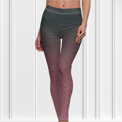 A pair of women's custom high waisted leggings that start as black at the top then fade to a light pink at the bottom, there are hearts all over the leggings then they fade into the black at the top of the pant.