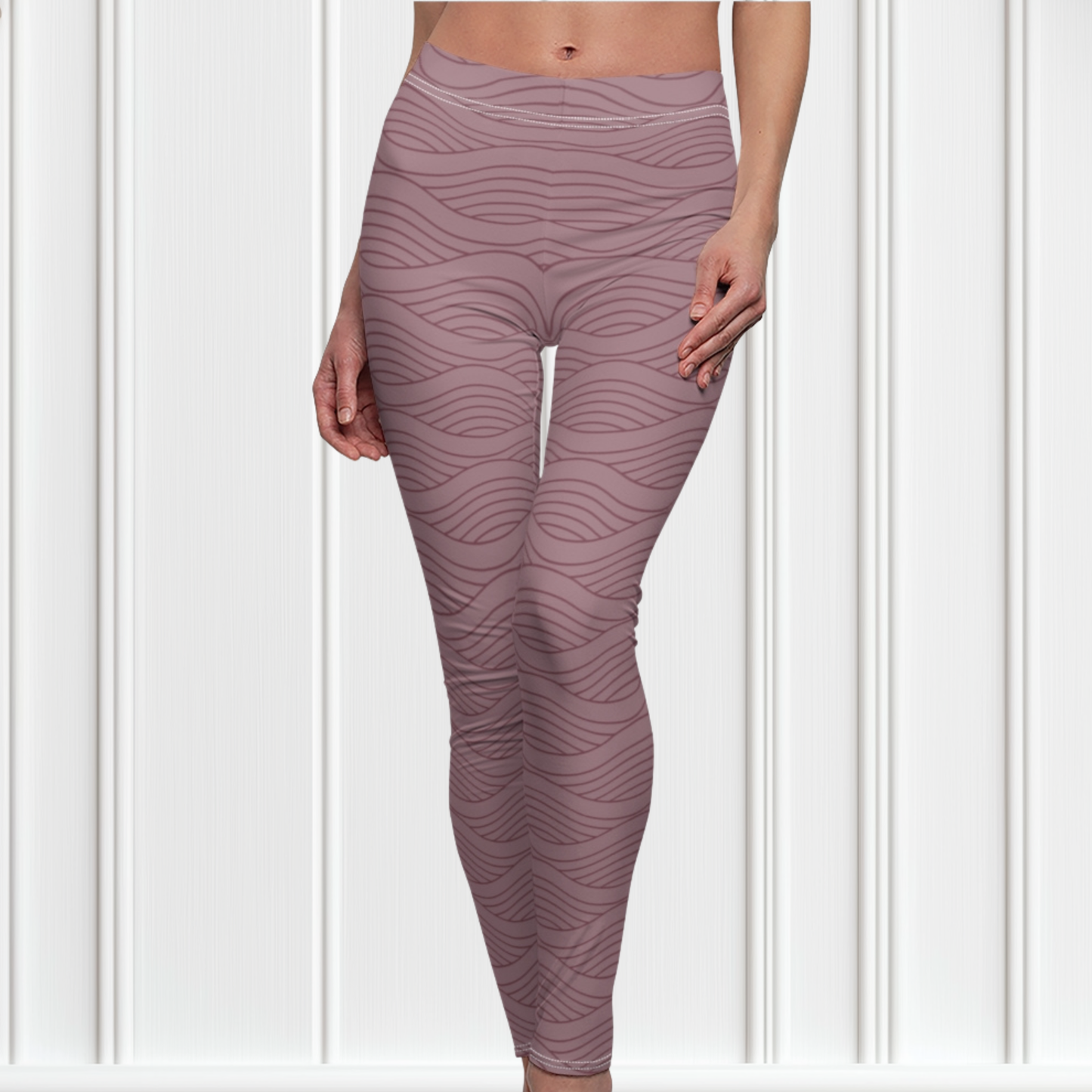 A pair of women's high waisted custom handmade leggings that are a light mauve in color, there are wavy lines throughout the pants that is a deep rose color.