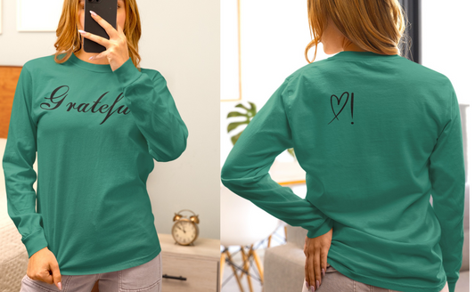 On the front of this custom long sleeve t-shirt in cursive writing is the word grateful on the upper chest, on the back left shoulder blade is an image of a heart with an exclamation mark next to it.