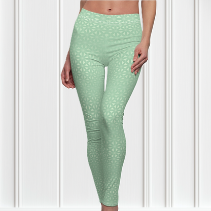 These high waisted women's leggings are a light green with a geometric pattern overlayed overtop, some spots are brighter than others showcasing some spots more than others.