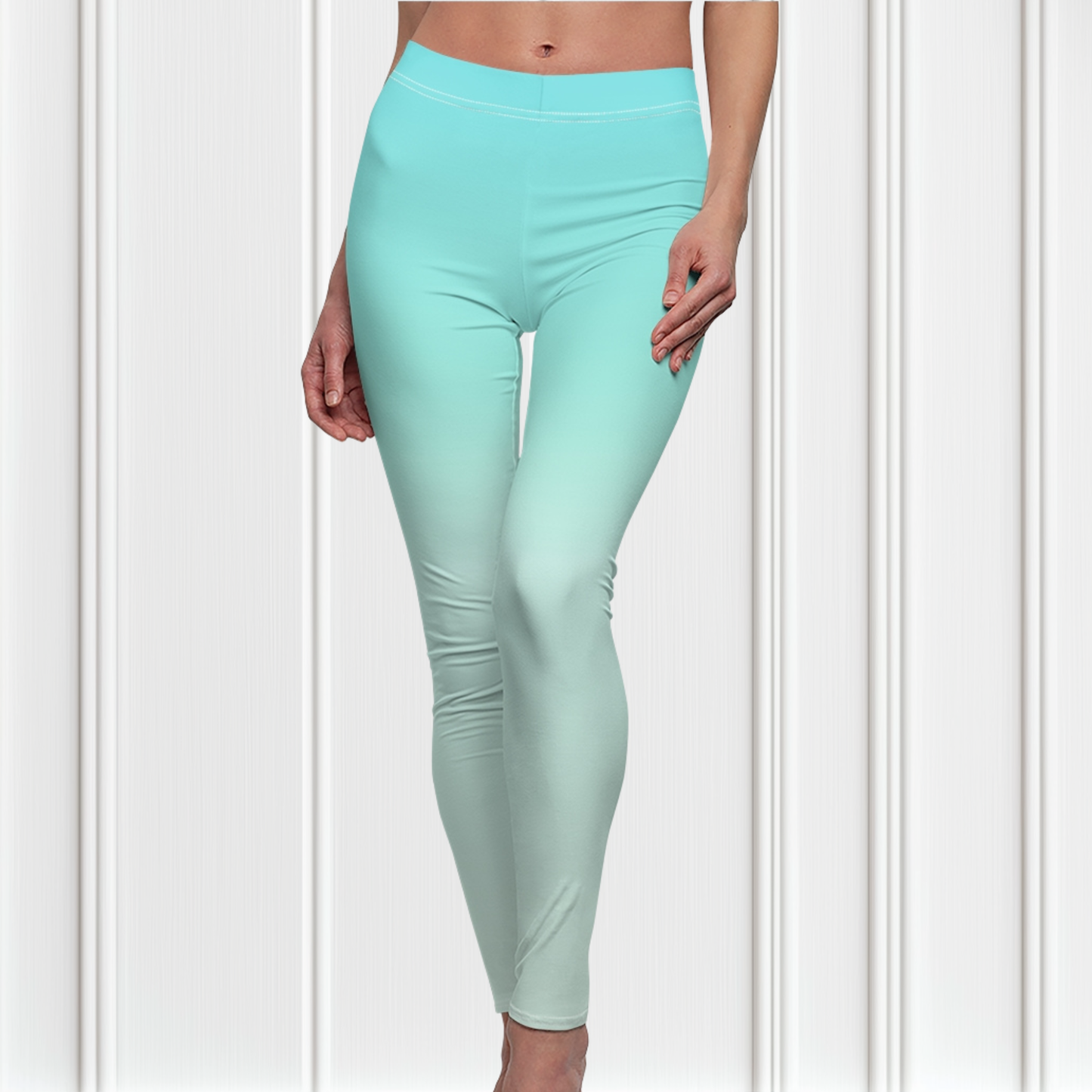 A pair of women's high waisted ankle length leggings that have a ombre pattern that starts as a medium ocean blue at the waistline then fades to a very light sky blue at the ankles of the pant.