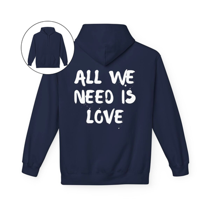 On the back of this custom unisex hoodie are the words all we need is love, the words look like they have been spray painted onto the sweater.
