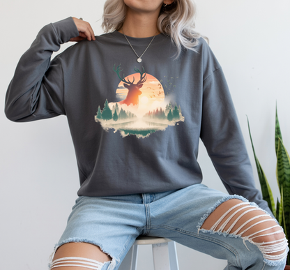 On the front of this custom unisex long sleeve shirt is beautiful landscape at dawn, there is a river in the middle with pine trees on either side, the sun is setting in the background with a large elk in the distance standing in front of the sun.