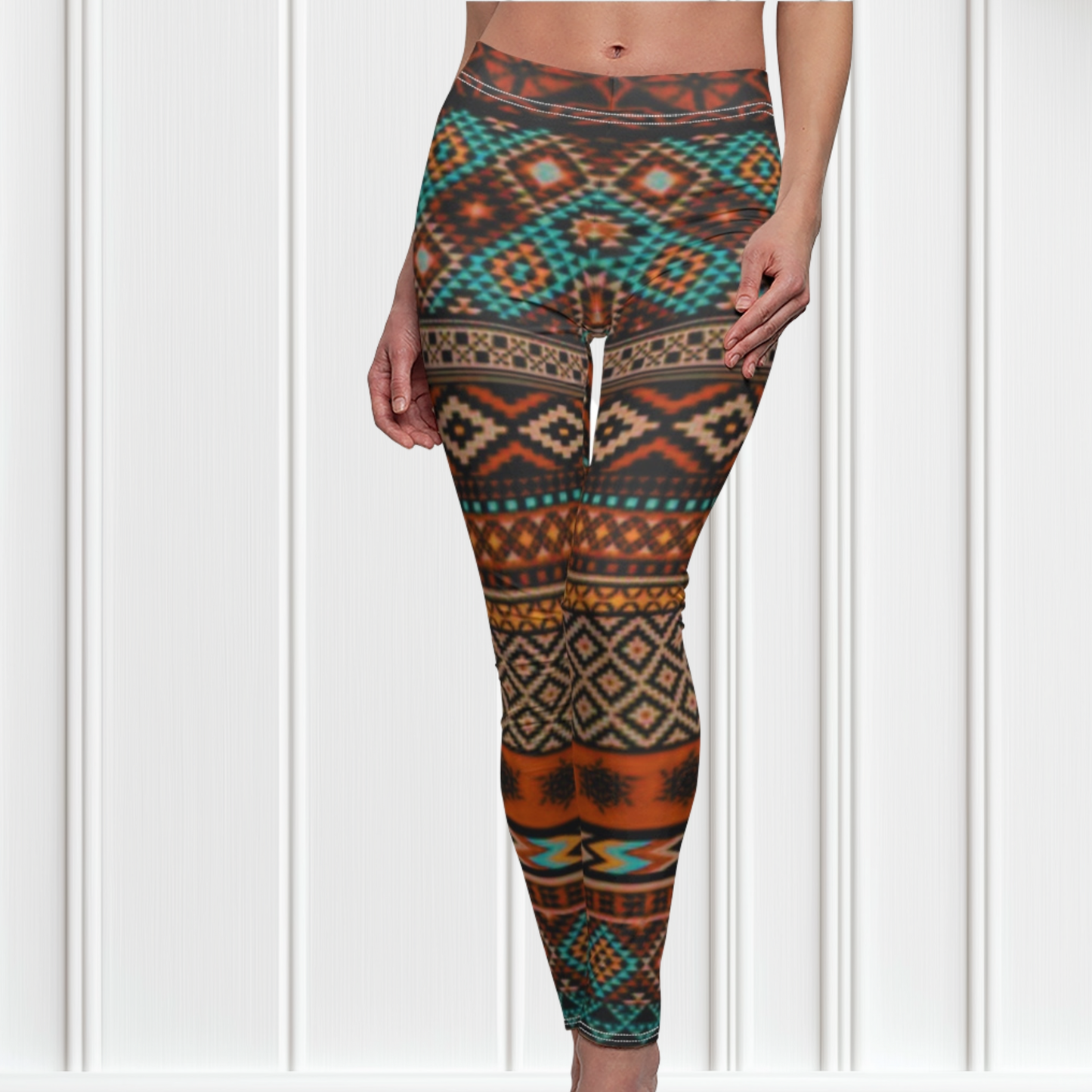 A pair of super soft handmade women's ankle length high waisted leggings. The pattern throughout the entire pair of pants is a orange, brown and blue Aztec pattern from the top of the pants to the bottom of the leggings.
