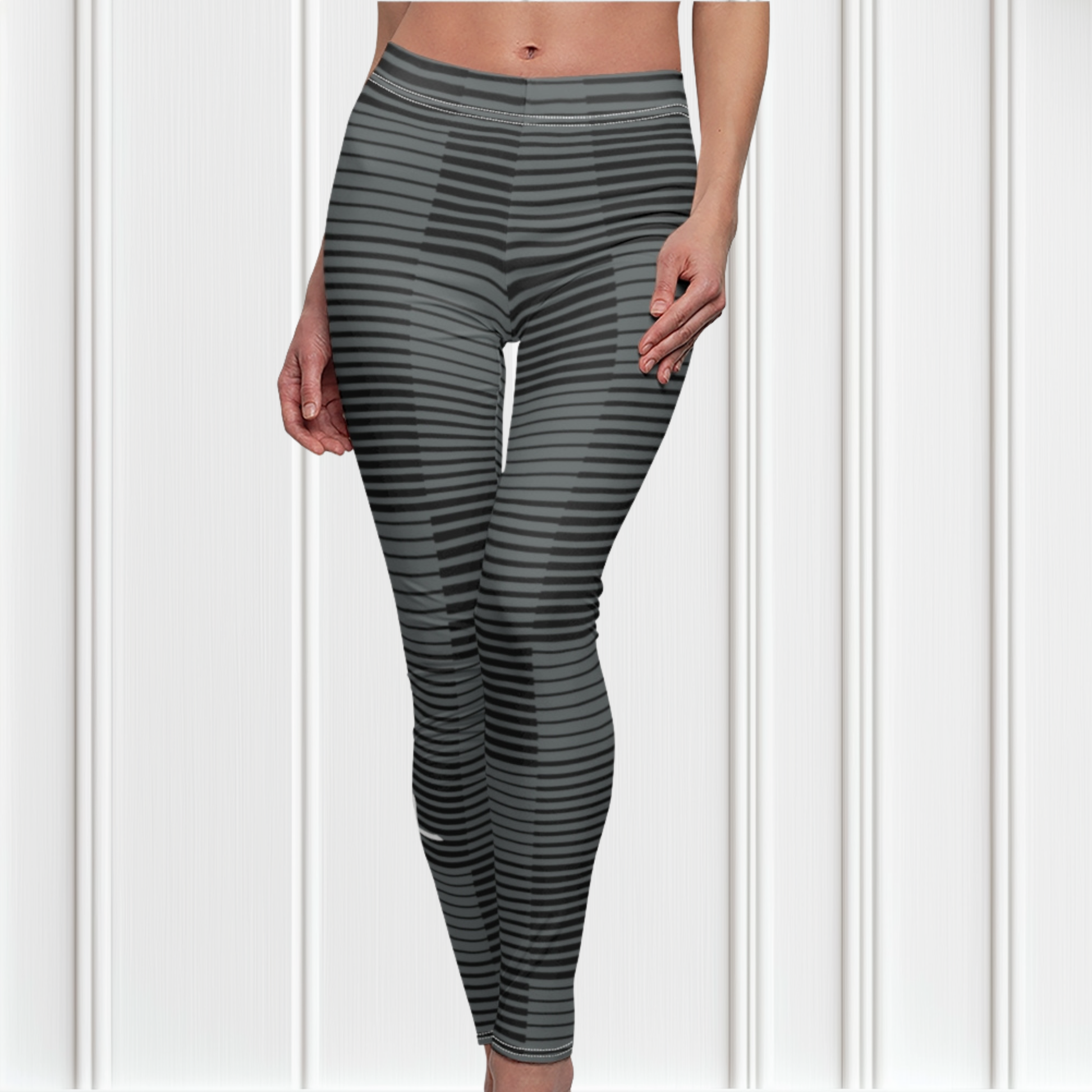 A pair of women's high waisted Christian themed leggings, the pants are light grey  color with black stripes running across the pants, the lines are in different thicknesses from the top to the bottom ankle of the leggings giving it a 3D look when worn, there is a white Jesus cross on the bottom right calf of the pant.