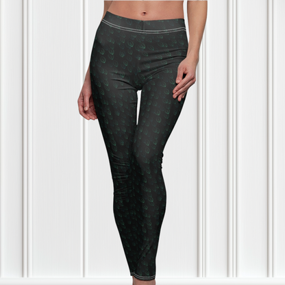 Custom high waisted women's leggings that are all black in color with a pattern of light green leaves all over the pants.