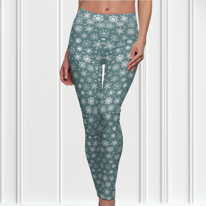 A pair of high waisted custom women's leggings that are a light blue in color and have white snowflakes all over the pants, perfect for Christmas.