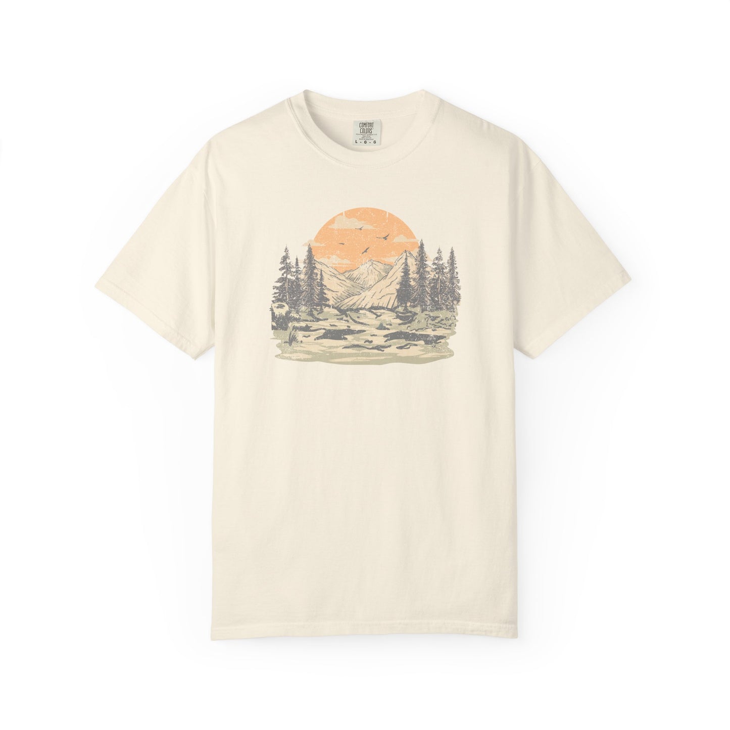 On the front of this custom comfort colors short sleeve t-shirt is a large vintage image of a large valley that opens up to a mountain range with pine trees , there is a large sun in the background with birds flying all around, this t-shirt is completely vintage.