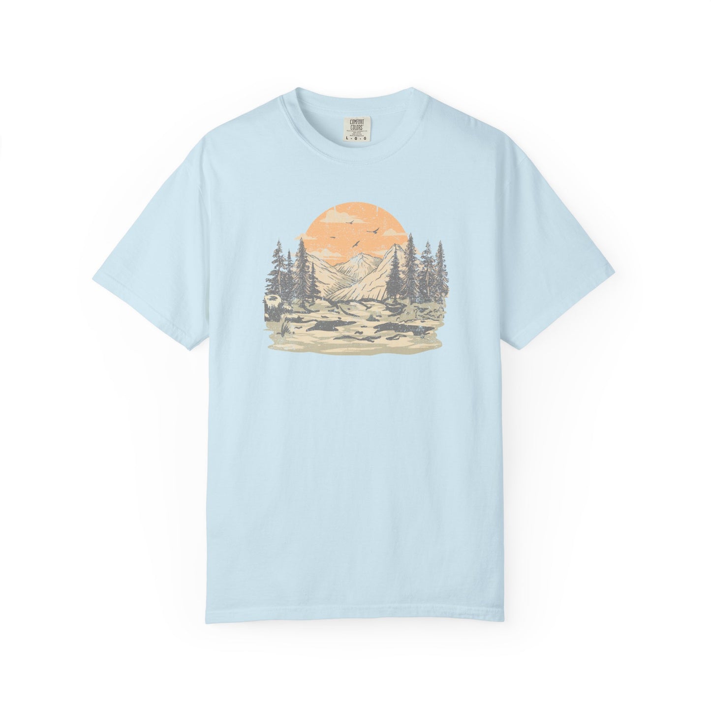 On the front of this custom comfort colors short sleeve t-shirt is a large vintage image of a large valley that opens up to a mountain range with pine trees , there is a large sun in the background with birds flying all around, this t-shirt is completely vintage.