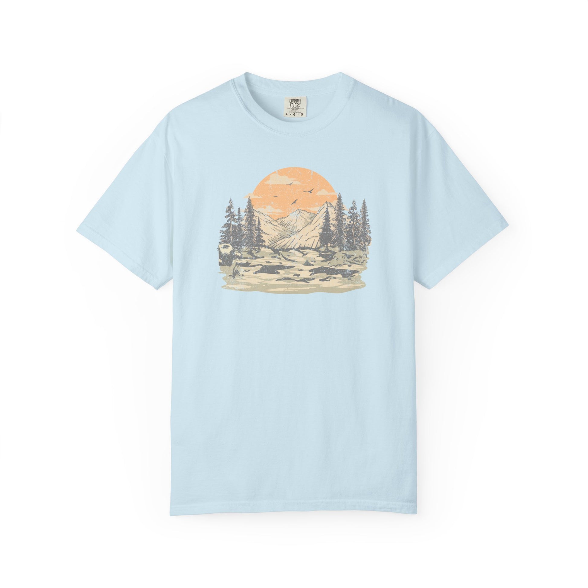 On the front of this custom comfort colors short sleeve t-shirt is a large vintage image of a large valley that opens up to a mountain range with pine trees , there is a large sun in the background with birds flying all around, this t-shirt is completely vintage.