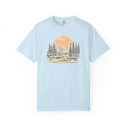 On the front of this custom comfort colors short sleeve t-shirt is a large vintage image of a large valley that opens up to a mountain range with pine trees , there is a large sun in the background with birds flying all around, this t-shirt is completely vintage.