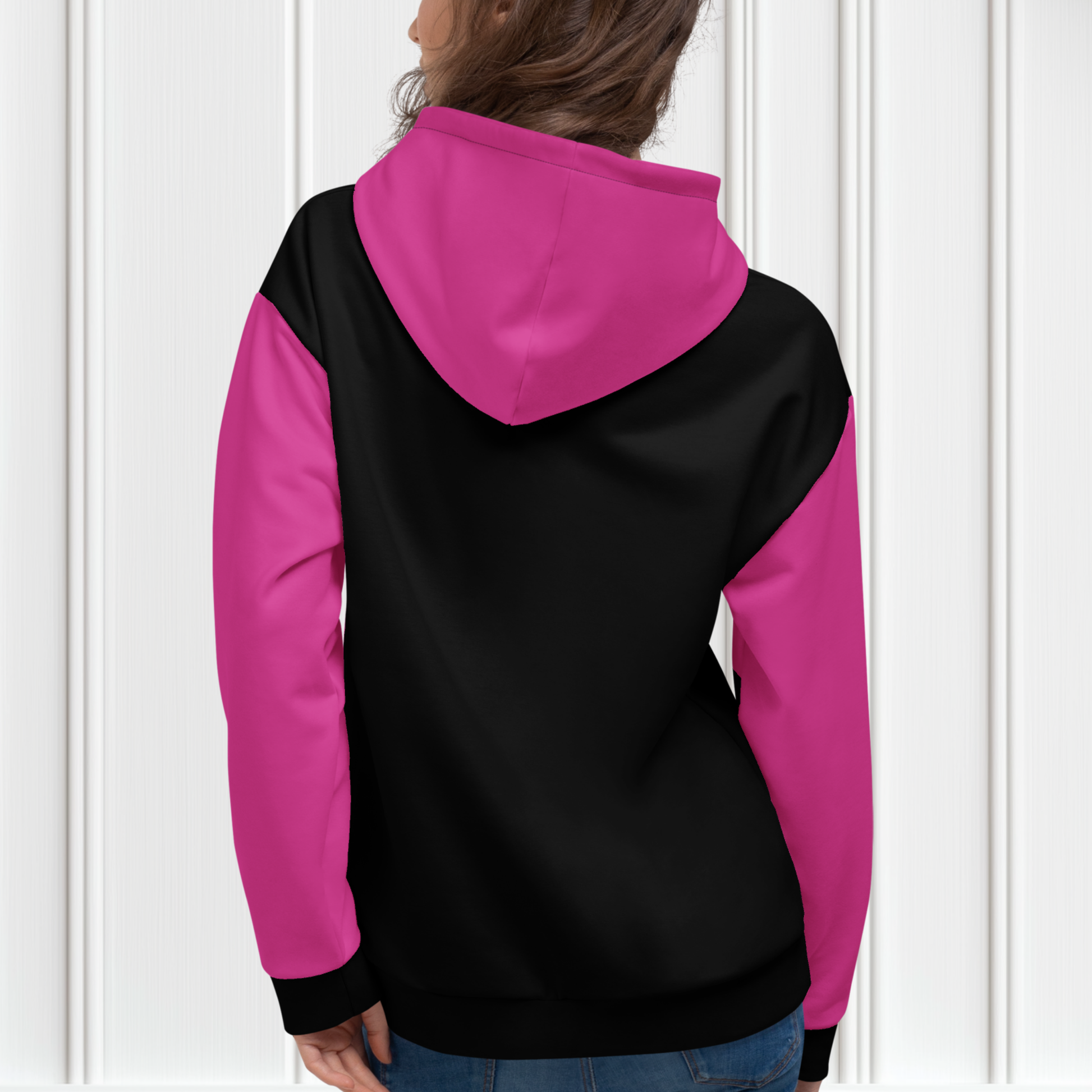 A women's custom oversized handmade hoodie, on the front and the back of the hoodie is the color black, the sleeves, front kangaroo pocket and hood are all a bright pink color, the strings of the sweater are black.