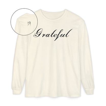 On the front of this custom long sleeve t-shirt in cursive writing is the word grateful on the upper chest, on the back left shoulder blade is an image of a heart with an exclamation mark next to it.