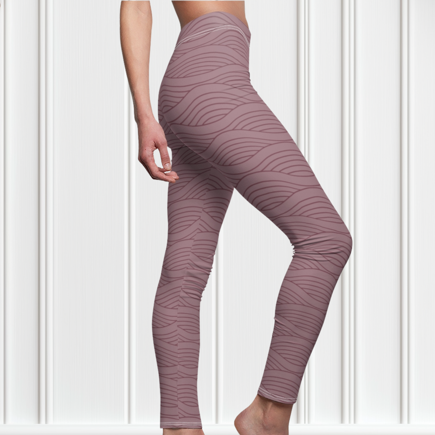 A pair of women's high waisted custom handmade leggings that are a light mauve in color, there are wavy lines throughout the pants that is a deep rose color.