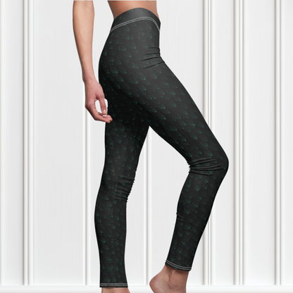 Custom high waisted women's leggings that are all black in color with a pattern of light green leaves all over the pants.