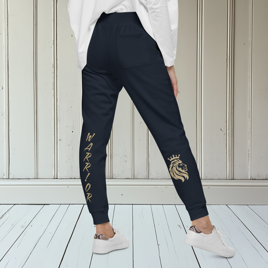 A pair of super soft ankle length unisex sweatpants, there are two pockets on the front and one pocket on the back right, the word warrior is in gold on the back left leg from the knee down and a male lion with a crown on the other