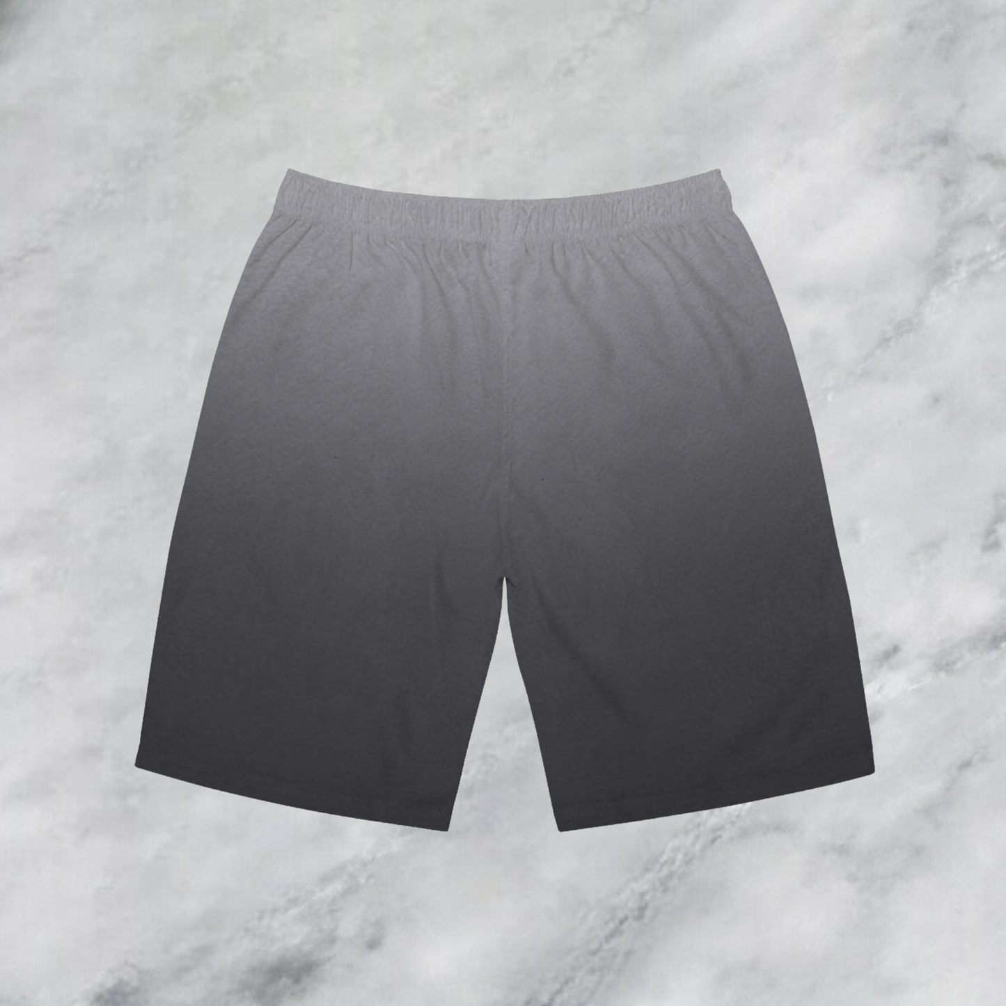 These custom men's board shorts feature a unique design with a ombre pattern starting with a light grey at the top then fading to a dark grey at the bottom, there is a symbol of a dove carrying a fig leaf on the front left side of the shorts just at the knee.