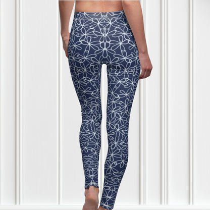 A pair of navy blue women's high waisted leggings with a white floral pattern all over the handmade pants.