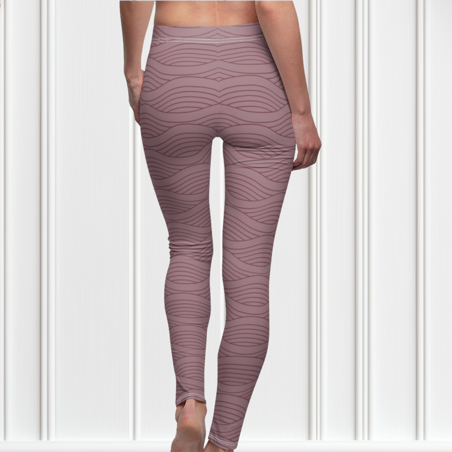 A pair of women's high waisted custom handmade leggings that are a light mauve in color, there are wavy lines throughout the pants that is a deep rose color.