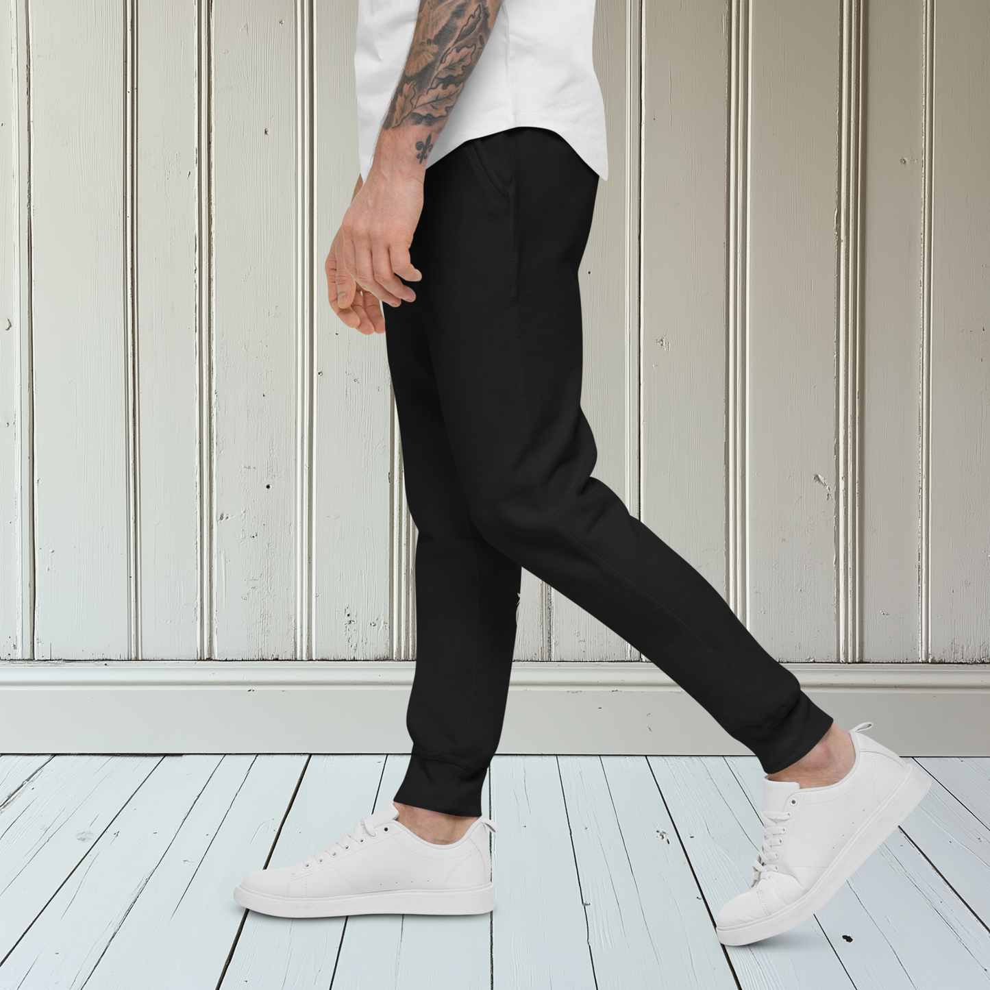 A pair of super soft custom unisex fleece sweatpants with a male lion head on the back calf of the right leg embroidered in silver.