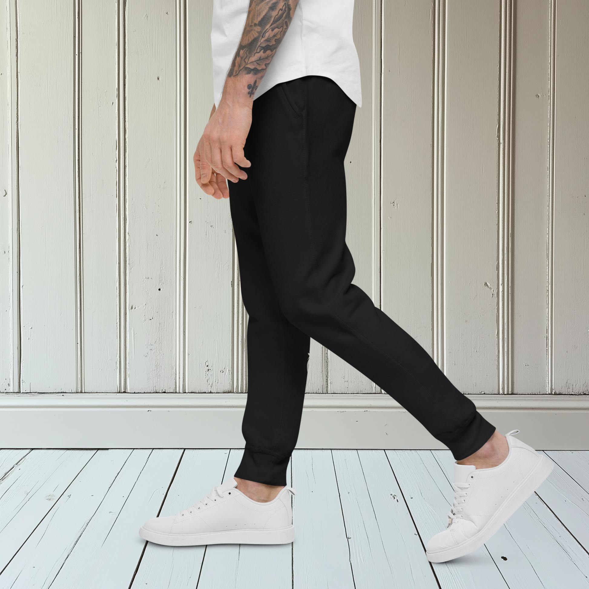 A pair of super soft custom unisex fleece sweatpants with a male lion head on the back calf of the right leg embroidered in silver.