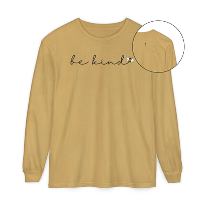 On the front of this custom unisex long sleeve shirt are the words be kind in a simple cursive font, with a bumble bee on the right side of the letter kind, on the back right shoulder there is an image of a bumble bee flying and leaving a trail behind it in the shape of a heart.