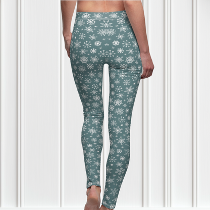 A pair of high waisted custom women's leggings that are a light blue in color and have white snowflakes all over the pants, perfect for Christmas.