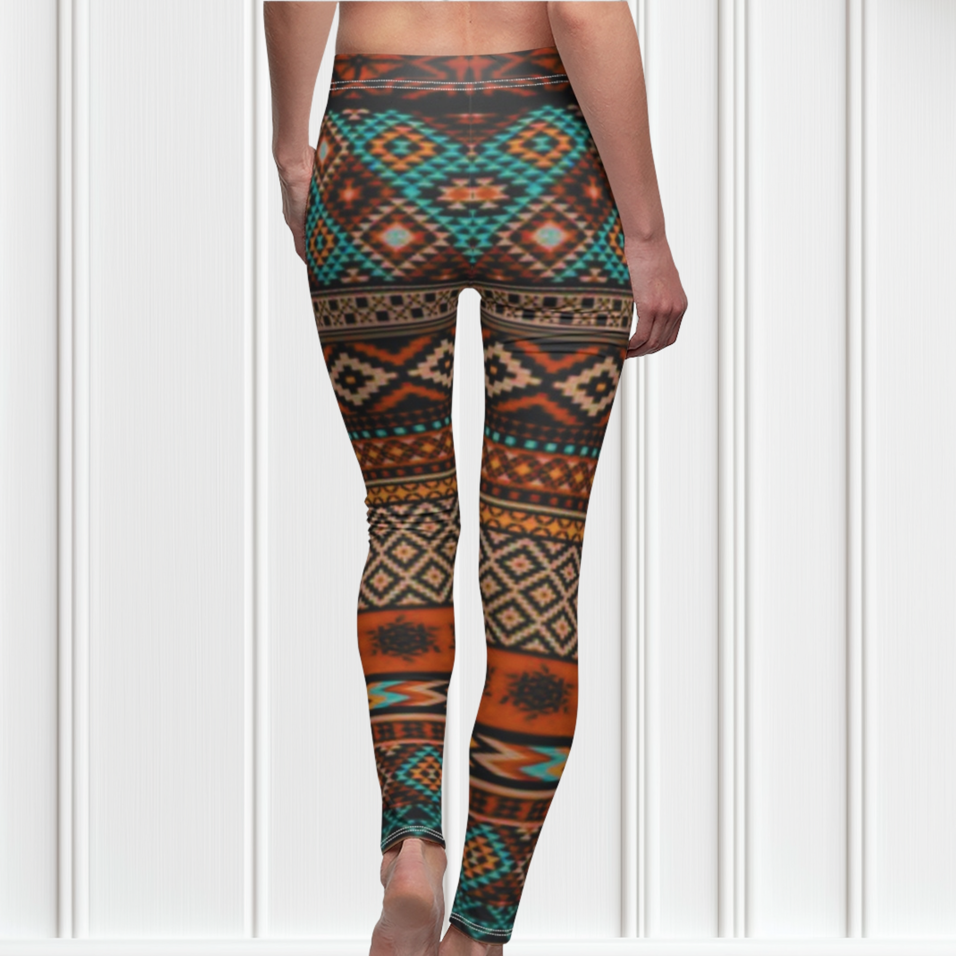 A pair of super soft handmade women's ankle length high waisted leggings. The pattern throughout the entire pair of pants is a orange, brown and blue Aztec pattern from the top of the pants to the bottom of the leggings.