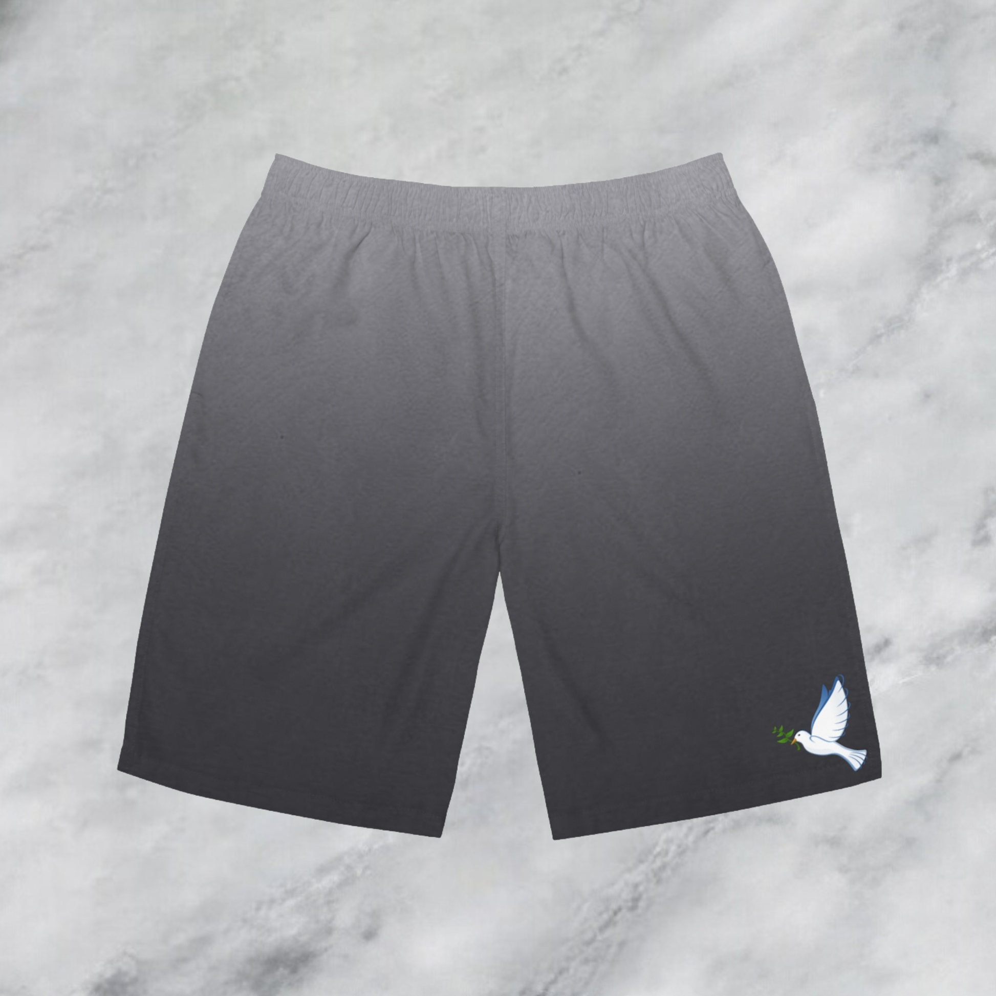 These custom men's board shorts feature a unique design with a ombre pattern starting with a light grey at the top then fading to a dark grey at the bottom, there is a symbol of a dove carrying a fig leaf on the front left side of the shorts just at the knee.