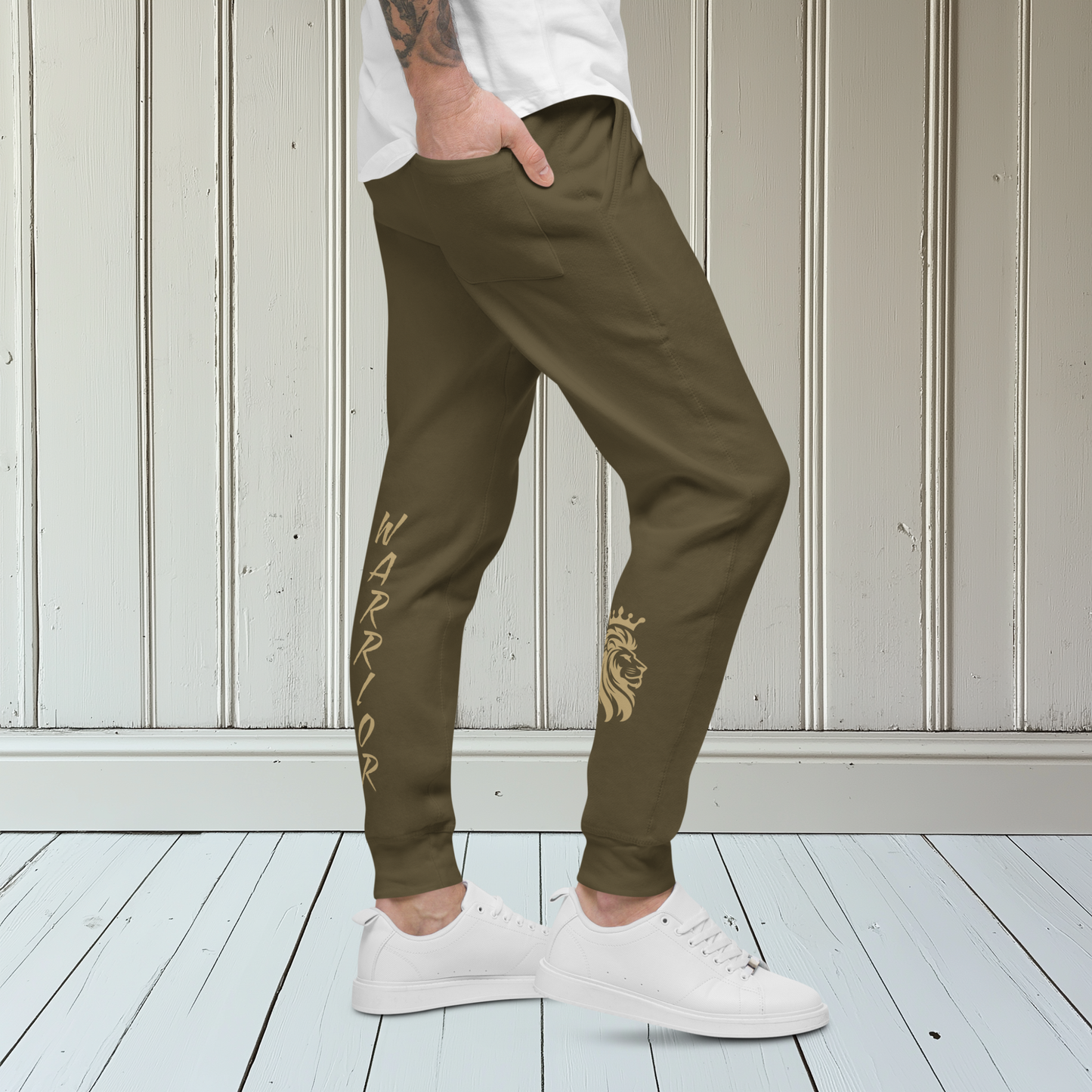 A pair of super soft ankle length unisex sweatpants, there are two pockets on the front and one pocket on the back right, the word warrior is in gold on the back left leg from the knee down and a male lion with a crown on the other