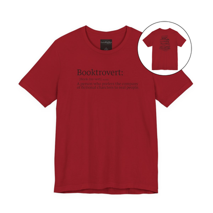 On the front of this custom unisex short sleeve shirt is the word booktrovert with the definition of the word underneath, on the back of the shirt is an image of a large stack of books.