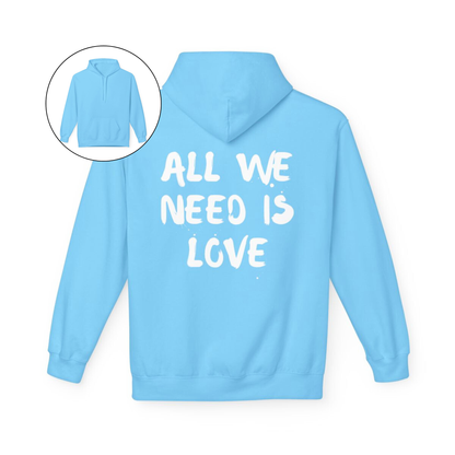 On the back of this custom unisex hoodie are the words all we need is love, the words look like they have been spray painted onto the sweater.