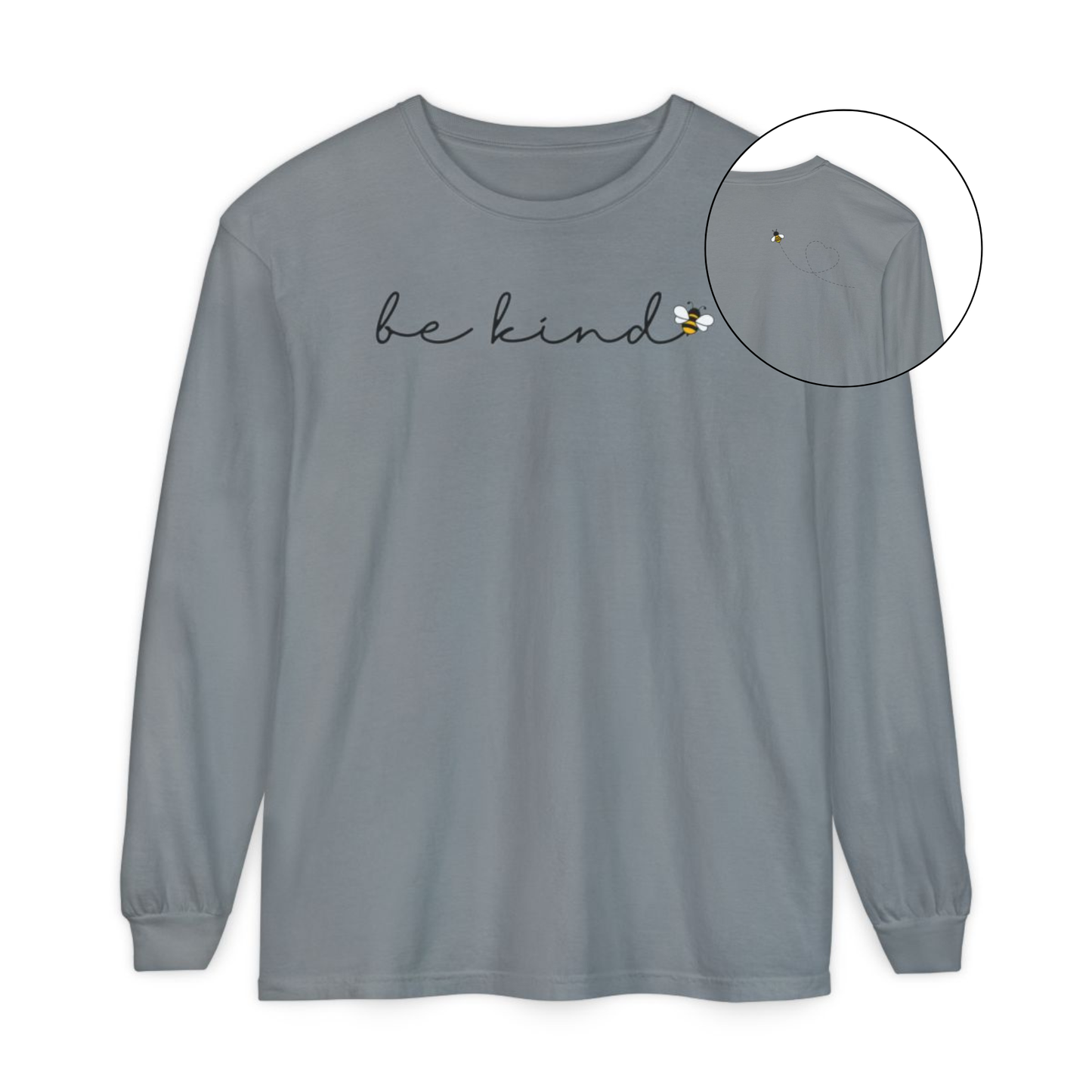 On the front of this custom unisex long sleeve shirt are the words be kind in a simple cursive font, with a bumble bee on the right side of the letter kind, on the back right shoulder there is an image of a bumble bee flying and leaving a trail behind it in the shape of a heart.