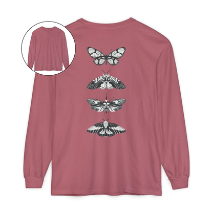 On the back of this long sleeve women's shirt right in between the shoulder blades is a row of black and white butterflies, starting at the top of the back and headed to the bottom of the shirt.