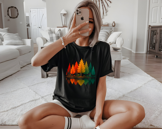 On the front of this custom comfort colors short sleeve shirt is a image of trees in the fall time with all the different fall colors, the trees reflection is right underneath making them look like they are above water.