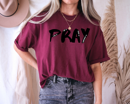 On the front of this custom handmade short sleeve shirt is the word pray in large black lettering, inside each letter in smaller writing are the words For it On it Over it and Through it in a different color font.