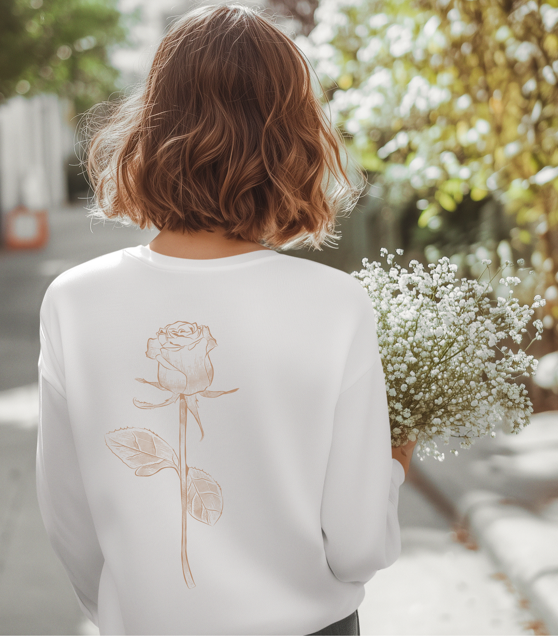 On the back of this custom women's long sleeve tee is a beige colored long stem rose that is the length of the shirt