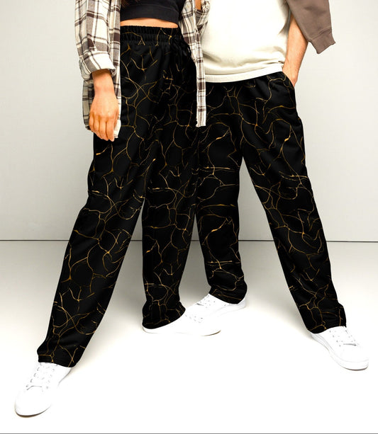 The super soft pair of wide leg sweatpants that are all black with gold ribbon running throughout the entire pair of pants giving them a marbled pattern.