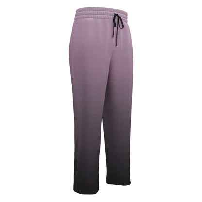 A pair of unisex wide leg joggers that have a ombre pattern starting with a lilac purple at the top then fading to a black at the bottom, the strings are black as well on this pair of pants.