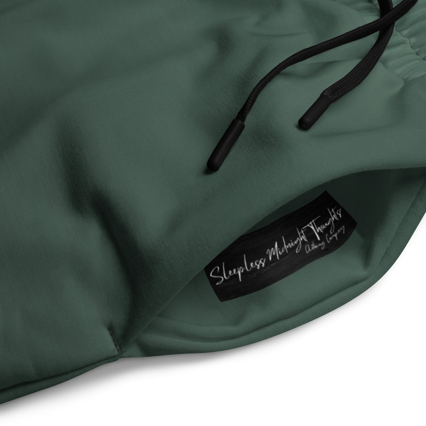 A custom pair of handmade unisex joggers that have an ombre pattern, the top of the pants have a teal green color that shifts to black at the bottom of the sweatpants, there is a black tie around the waist.