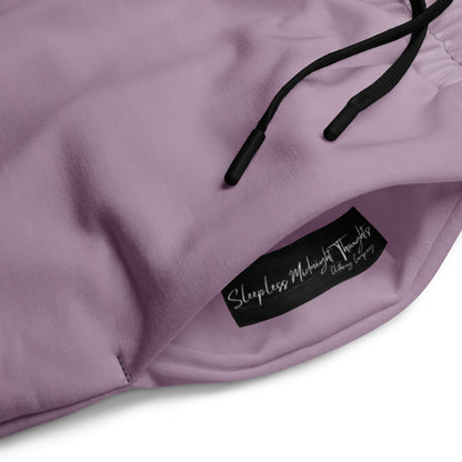 A pair of unisex wide leg joggers that have a ombre pattern starting with a lilac purple at the top then fading to a black at the bottom, the strings are black as well on this pair of pants.