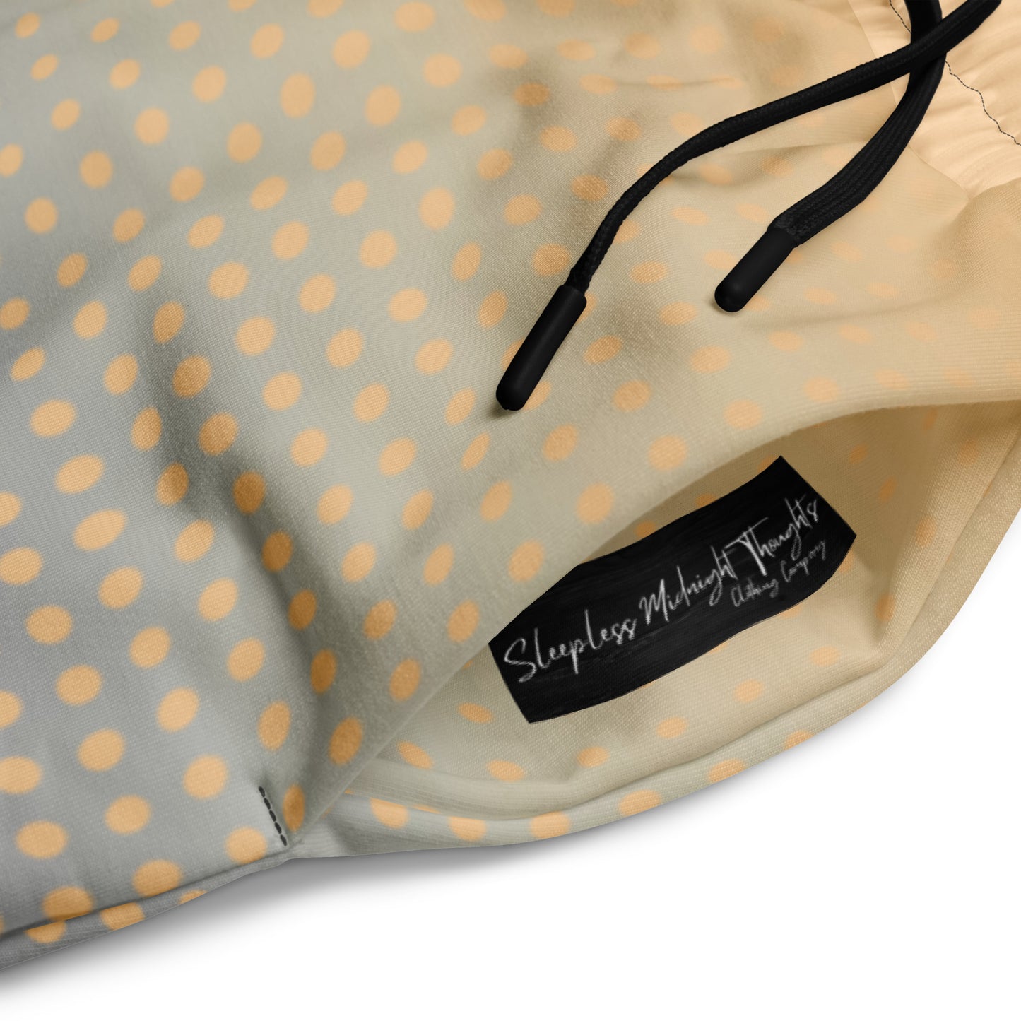 A pair of super soft unisex style wide leg jogger with a ombre pattern that starts as a light orange on the top the fades to a deep teal in the middle of the sweats, there is a polka dot pattern that is light orange throughout the top as well.