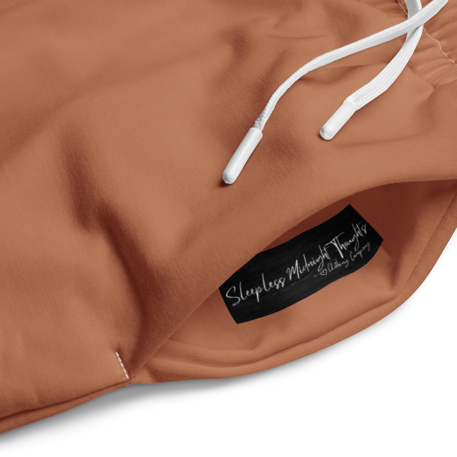 A custom pair of wide leg joggers that are a light caramel brown in color and have white strings around the waistband.