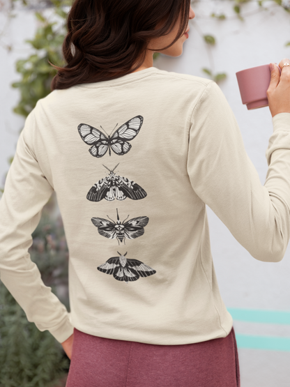 On the back of this long sleeve women's shirt right in between the shoulder blades is a row of black and white butterflies, starting at the top of the back and headed to the bottom of the shirt.
