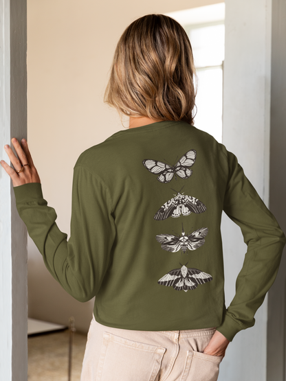 On the back of this long sleeve women's shirt right in between the shoulder blades is a row of black and white butterflies, starting at the top of the back and headed to the bottom of the shirt.