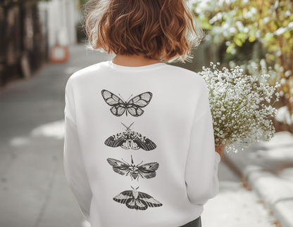 On the back of this long sleeve women's shirt right in between the shoulder blades is a row of black and white butterflies, starting at the top of the back and headed to the bottom of the shirt.