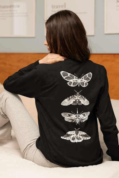 On the back of this long sleeve women's shirt right in between the shoulder blades is a row of black and white butterflies, starting at the top of the back and headed to the bottom of the shirt.