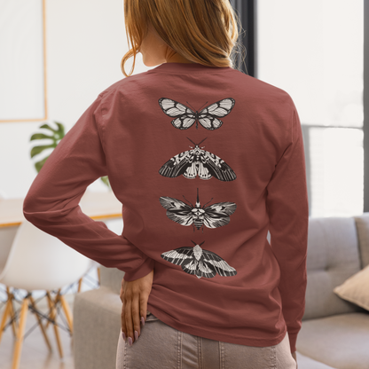 On the back of this long sleeve women's shirt right in between the shoulder blades is a row of black and white butterflies, starting at the top of the back and headed to the bottom of the shirt.